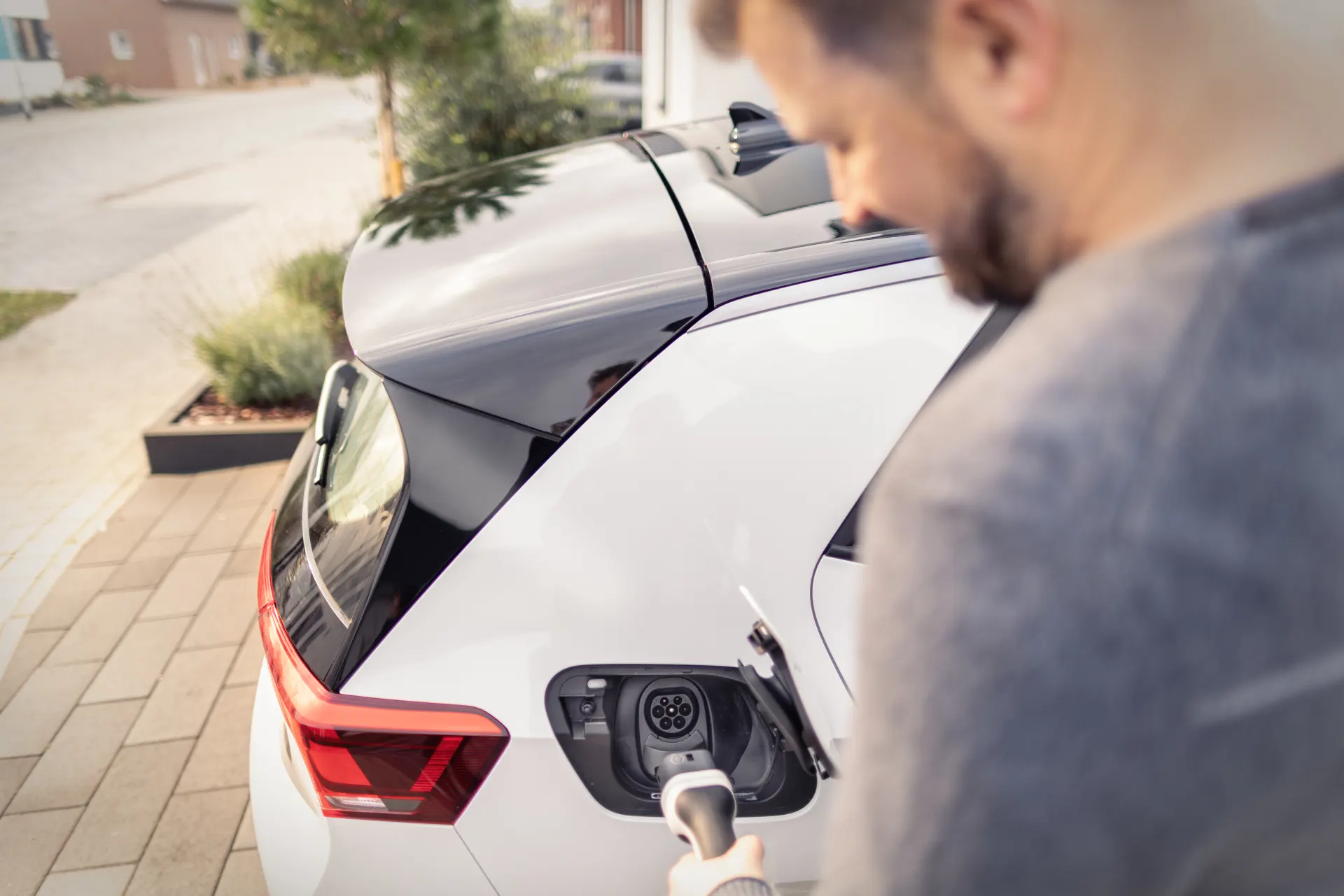 Ein Mann lädt sein Elektroauto mit seiner installierten Wallbox. 