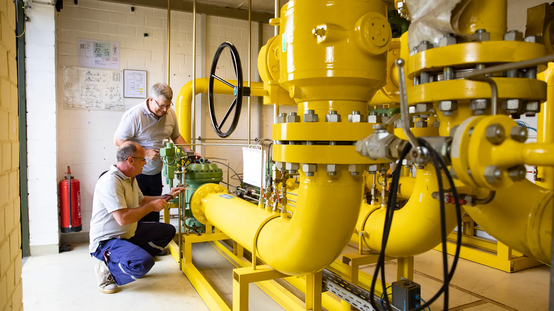 Installateure überprüfen ein Blockheizkraftwerk Zwei Installateure überprüfen eine Blockheizkraftwerk