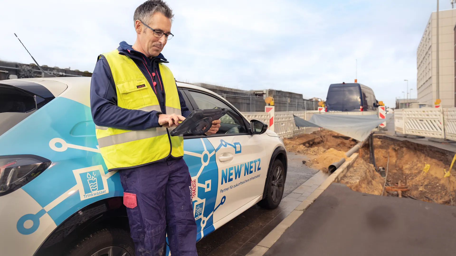Installateur ist auf einer Baustelle und informiert sich über technische Richtlinien. Installateur befindet sich auf einer Baustelle und informiert sich mit seinem Tablet über technische Richtlinien.