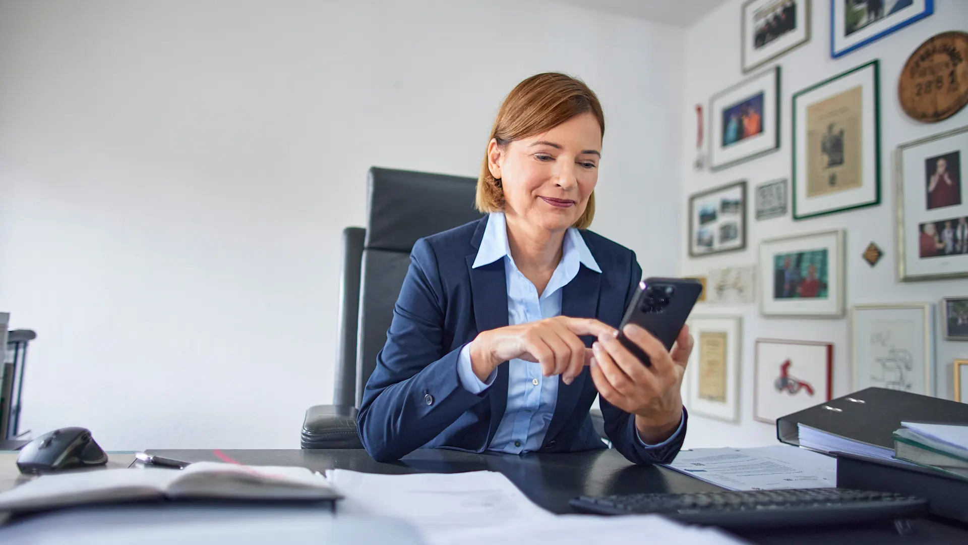 Mitarbeiterin am Smartphone, um eine Konzession zu bestätigen. Zu sehen ist eine Mitarbeiterin der NEW Netz, die an Ihrem Smartphone die Konzession eines Installateurs bearbeitet.