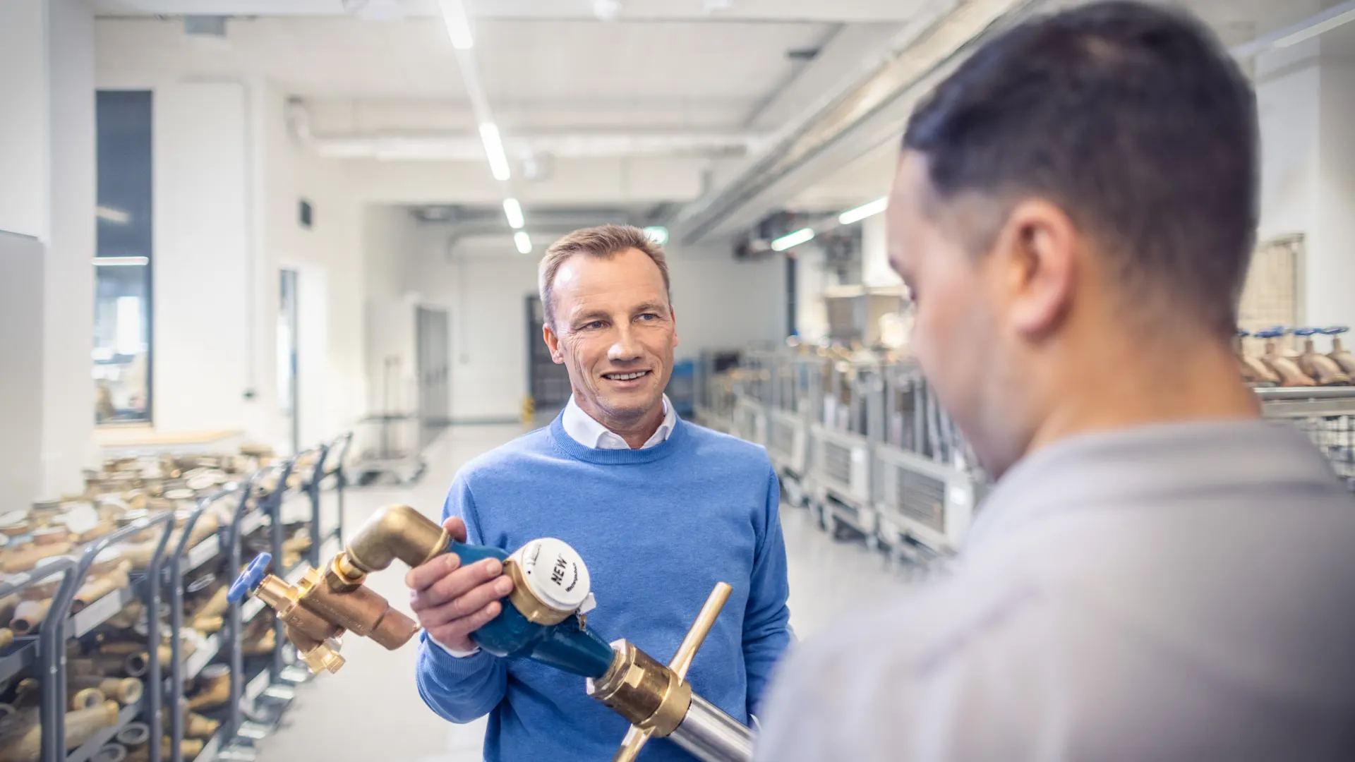 Installateur händigt ein Trinkwasser-Standrohr aus Installateur händigt ein Trinkwasser-Standrohr an einen Kunden aus