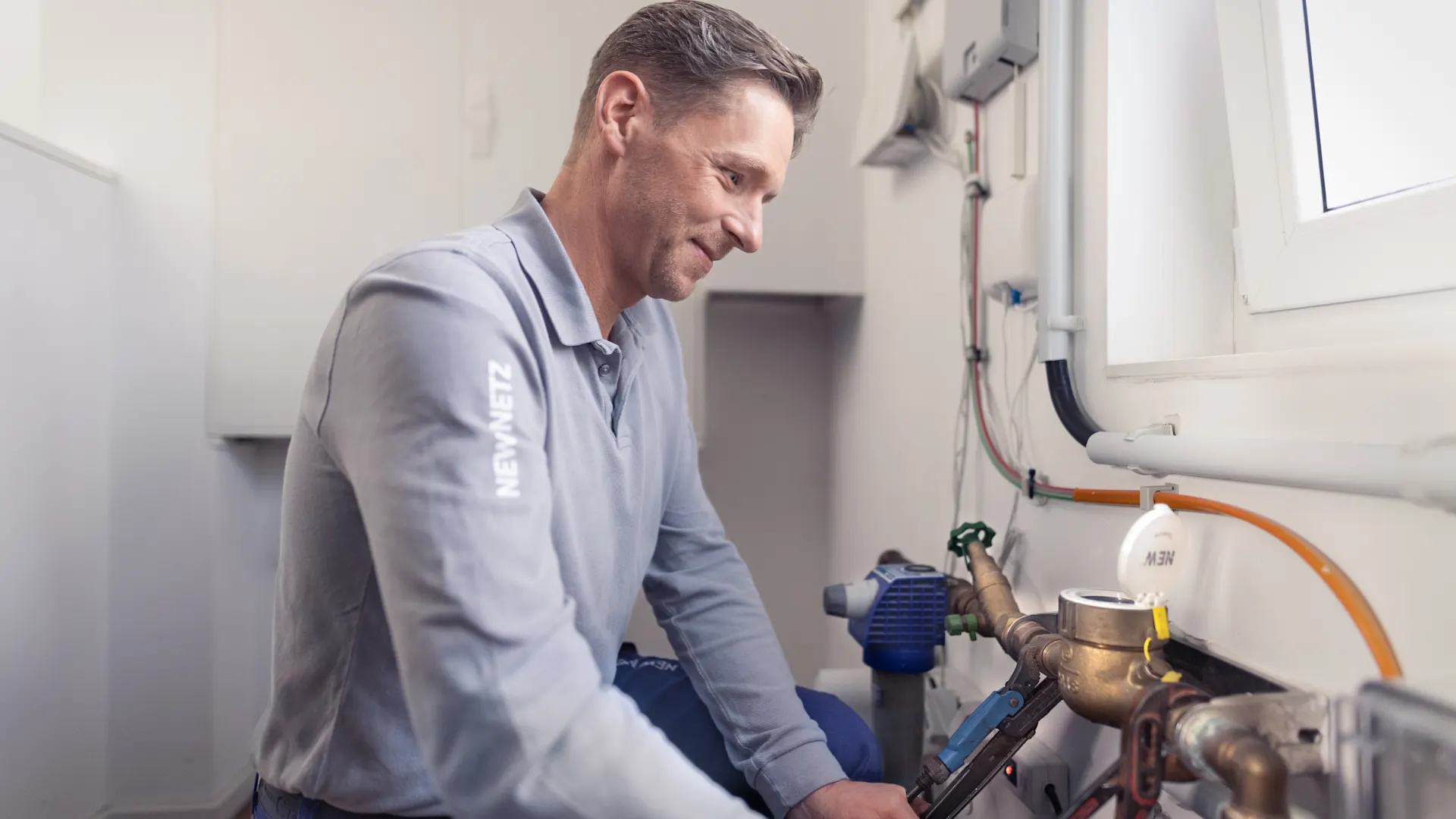 Installateur stellt die Wasserversorgung sicher  Ein Installateur arbeitete an der Wasseruhr und stellt die Wasserversorgung sicher