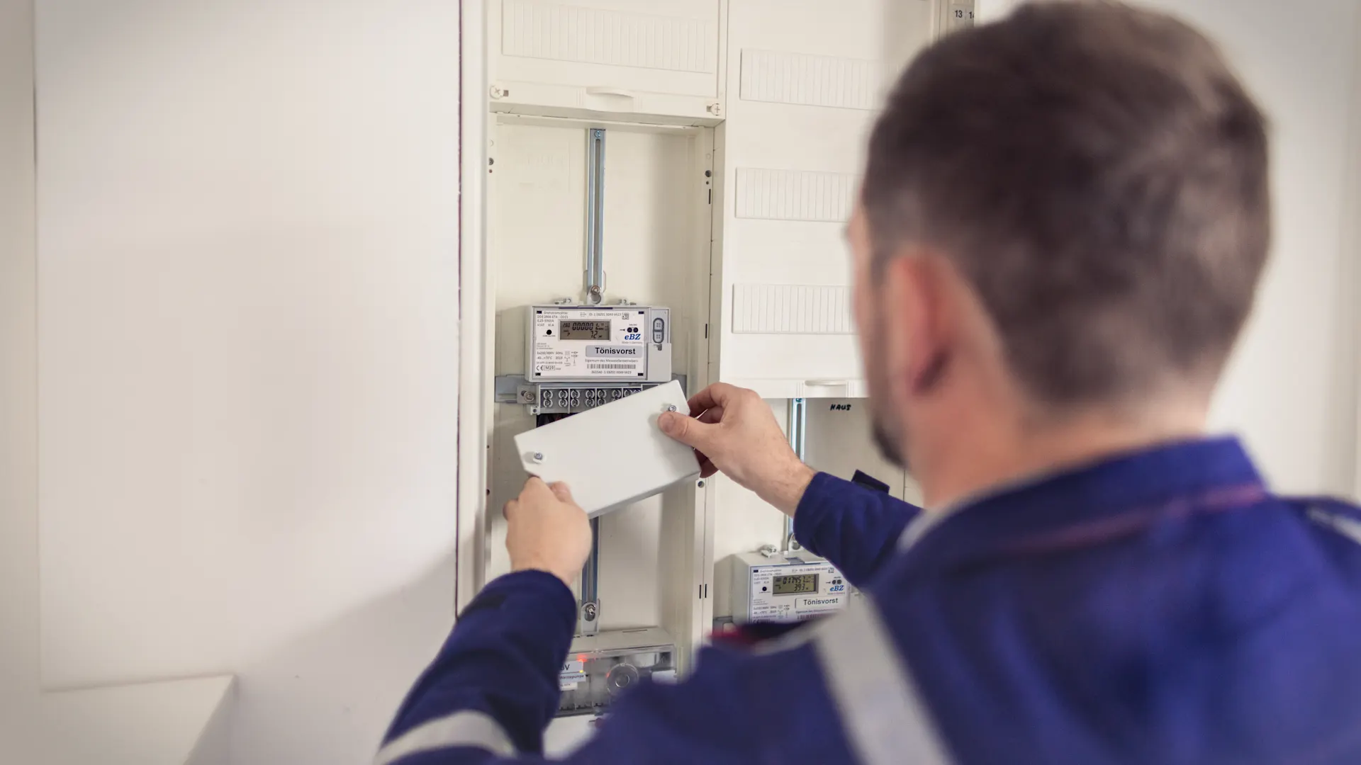 Installateur stellt die Stromversorgung sicher Ein Installateur arbeitet am Stromzähler und stellt die Stromversorgung sicher.