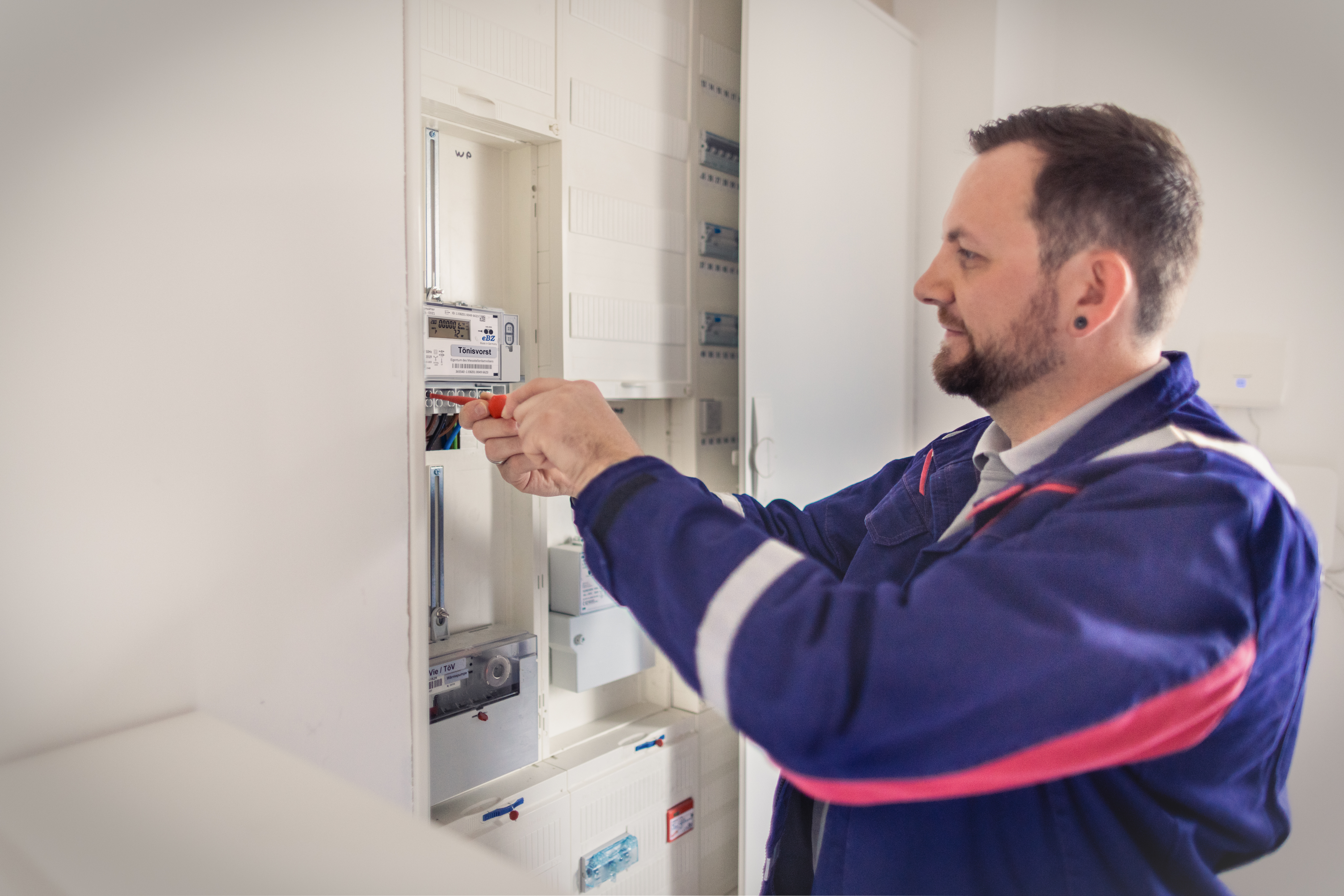 Ein Installateur der NEW Netz installiert eine steuerbare Verbrauchseinrichtung in einem Schaltschrank.