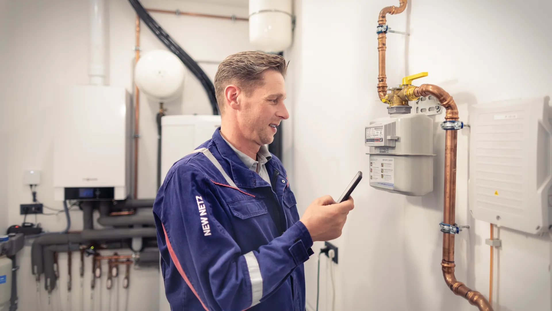 Installateur arbeitet an dem Messsystem des Haushaltes  Ein Installateur arbeitet an dem Schalt- und Messsystem des Haushaltes