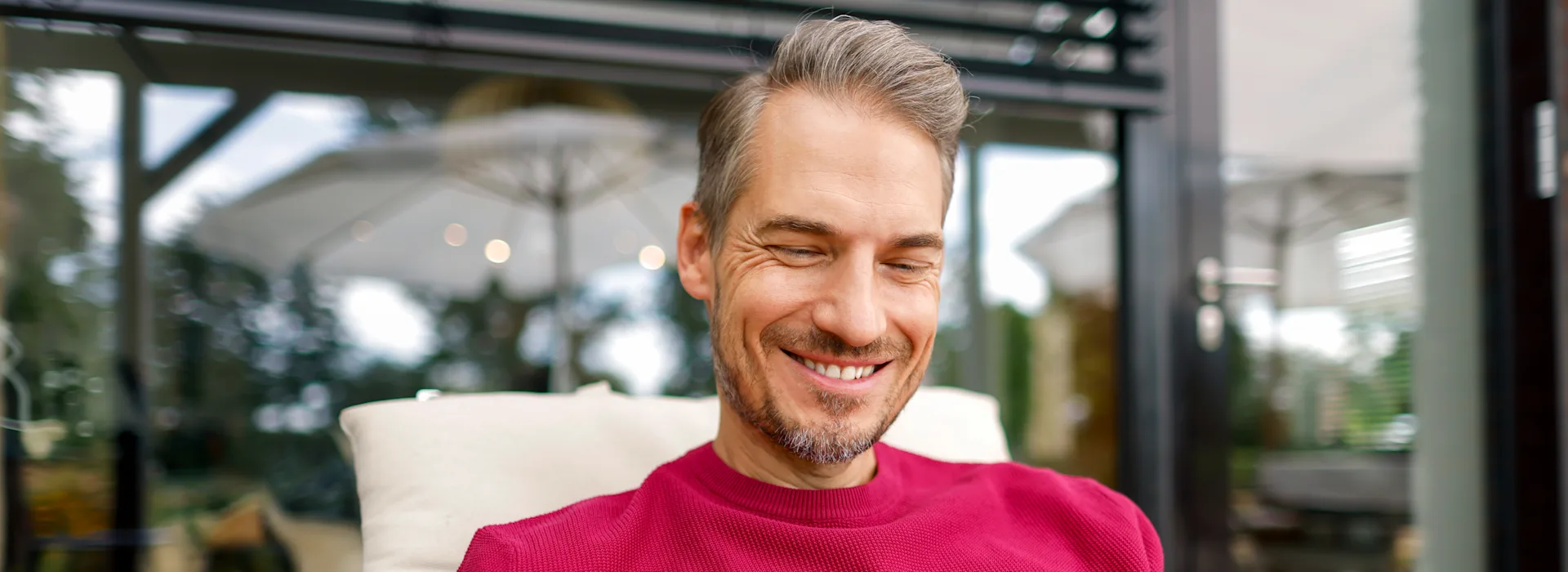Mann mit Smartphone vergleicht Preise Ein Mann liegt mit seinem Smartphone im Liegestuhl im Garten und vergleicht die Preise der NEW Energie.
