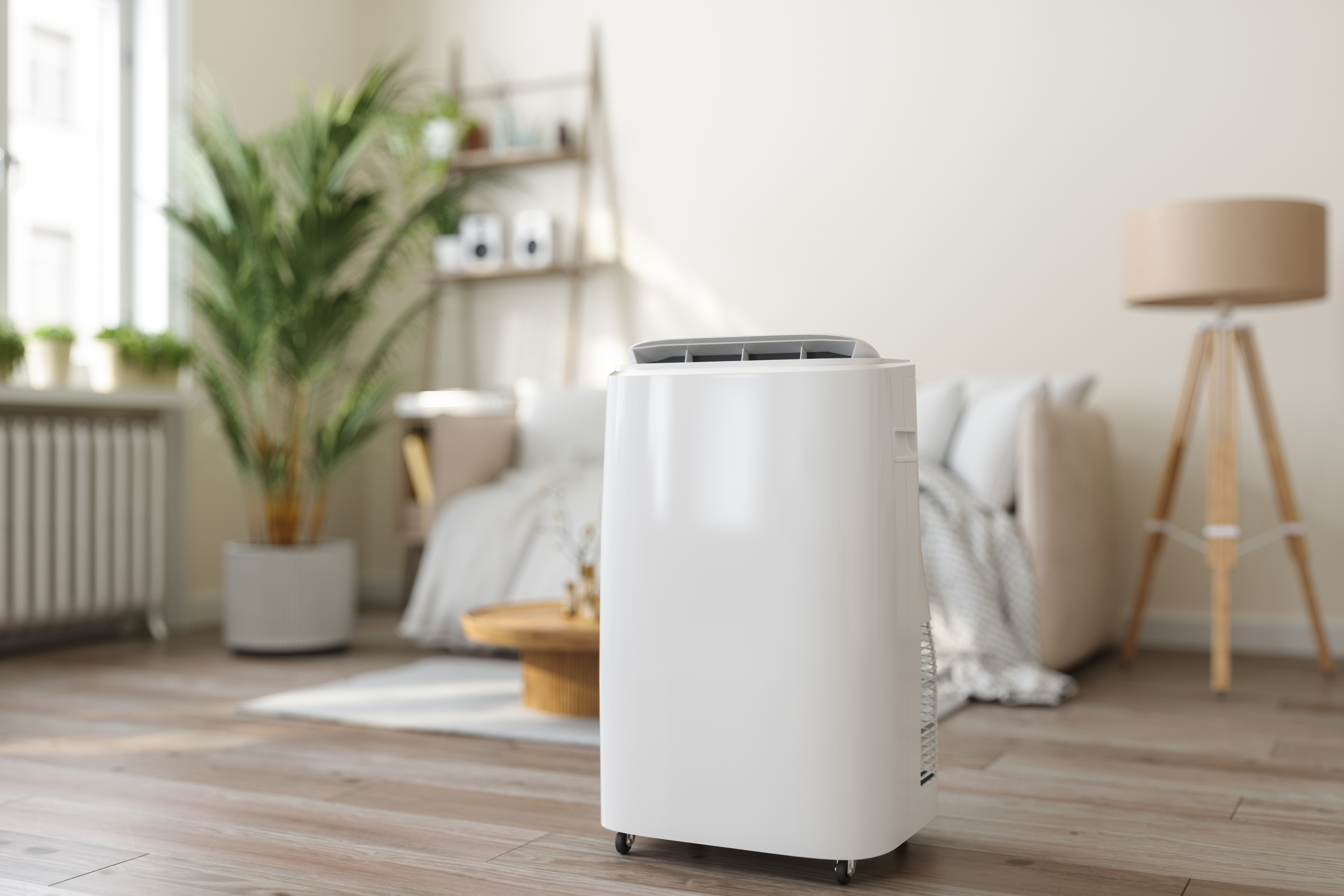 Eine mobile Klimaanlage steht in einem Wohnzimmer. Sie dient zur flexiblen Kühlung ohne feste Installation.