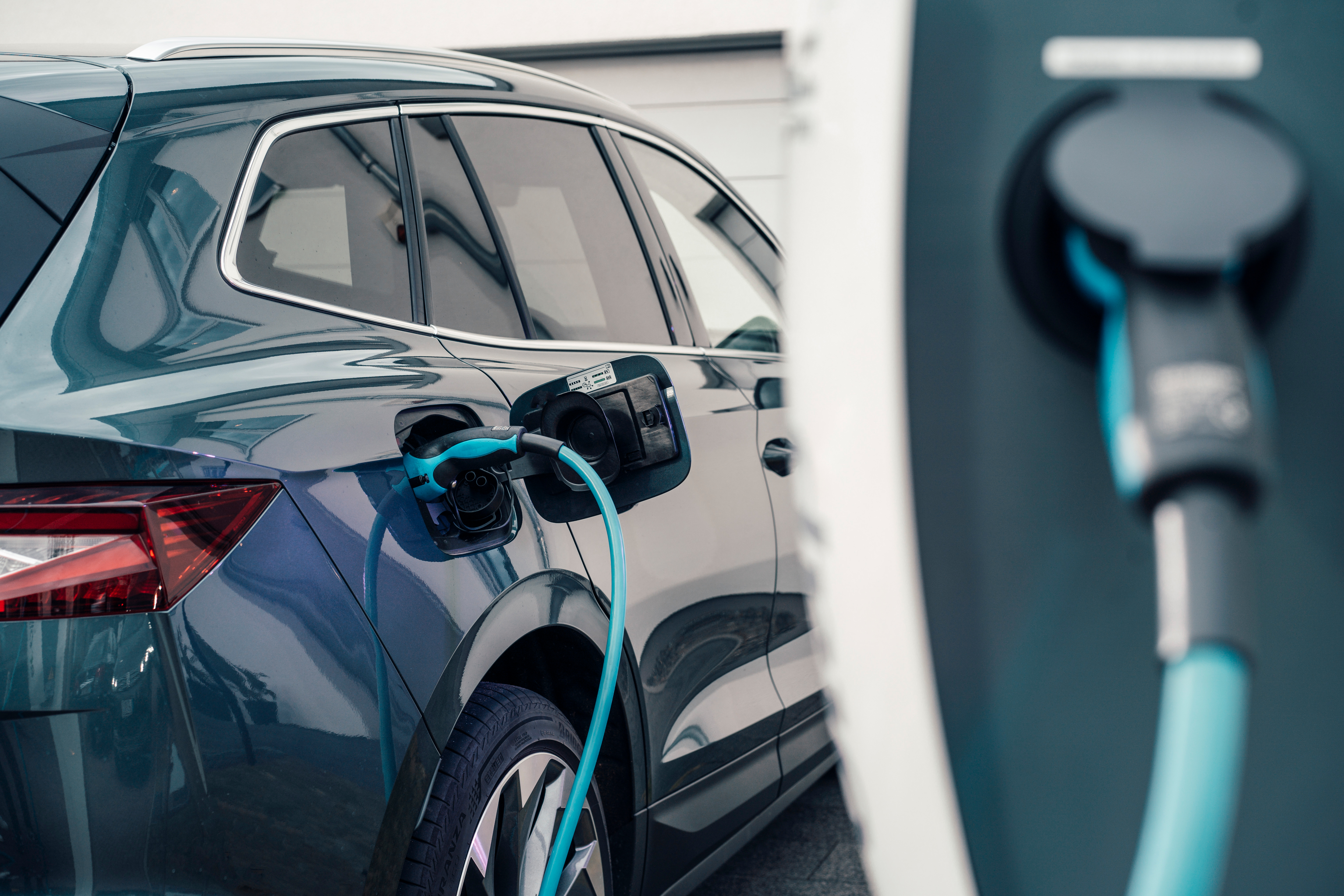 Ein Elektroauto wird zuhause vor der Garage mit Strom der NEW Energie geladen.