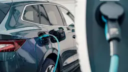 Elektroauto zu Hause laden Ein Elektroauto wird zuhause vor der Garage mit Strom der NEW Energie geladen.