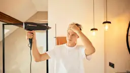 Haare föhnen mit Ökostrom Ein junger Mann föhnt sich die Haare mit Ökostrom, welcher günstigen Strom von dem Stromanbieter NEW Energie darstellt.
