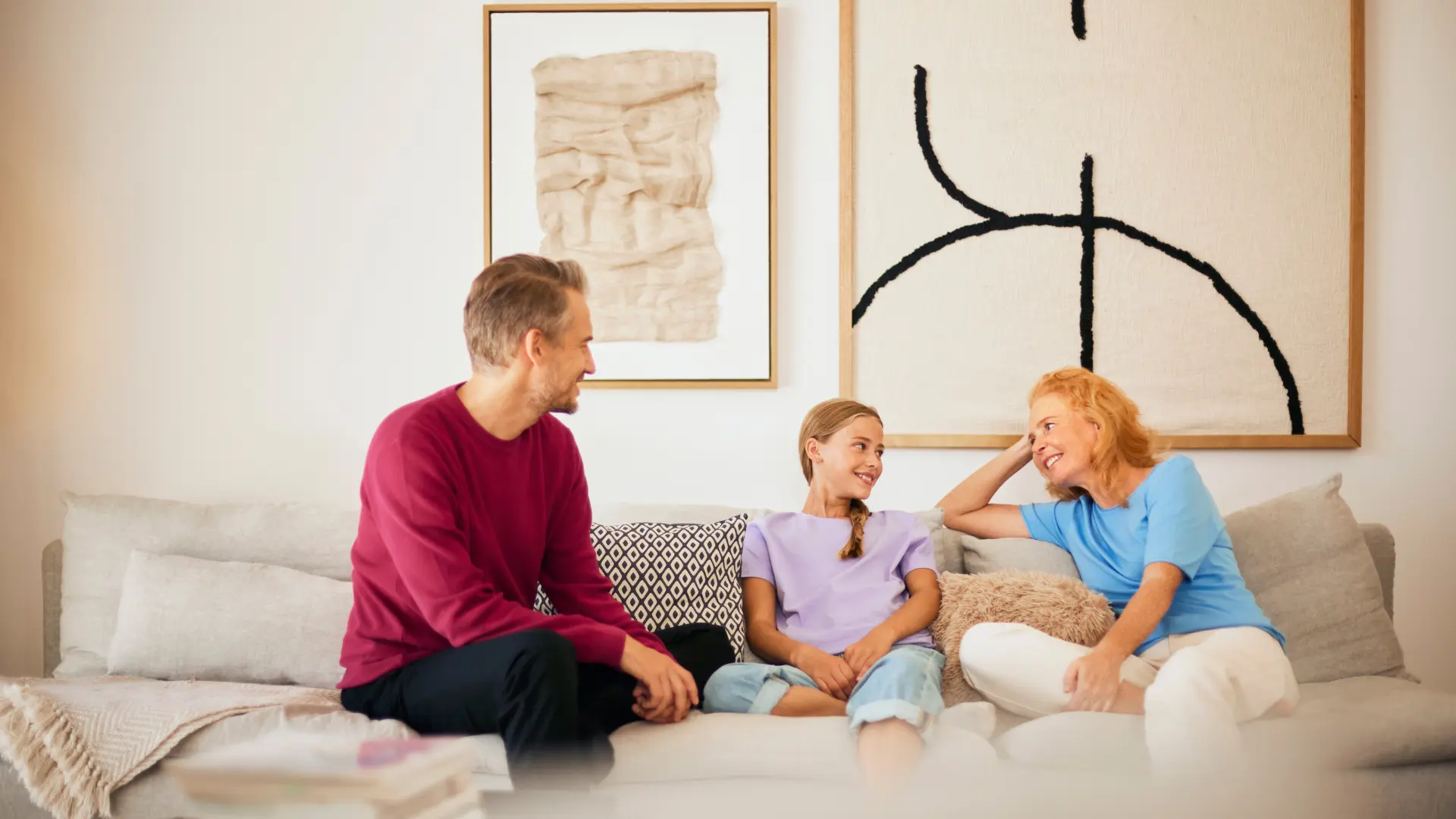 Eine Familie sitzt im Wohnzimmer und verbringt Familienzeit mit Gespraechen über Strom und Gas des Stromanbieters NEW Energie.