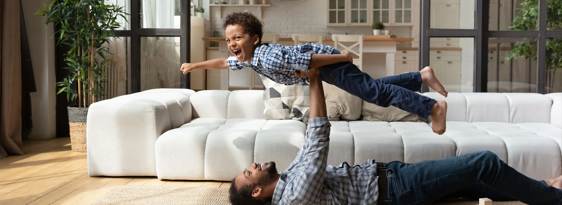 Vater und Sohn im Wohnzimmer Vater und Sohn liegen auf dem Wohnzimmerboden und spielen. Die Energie kommt von NEW Energie.