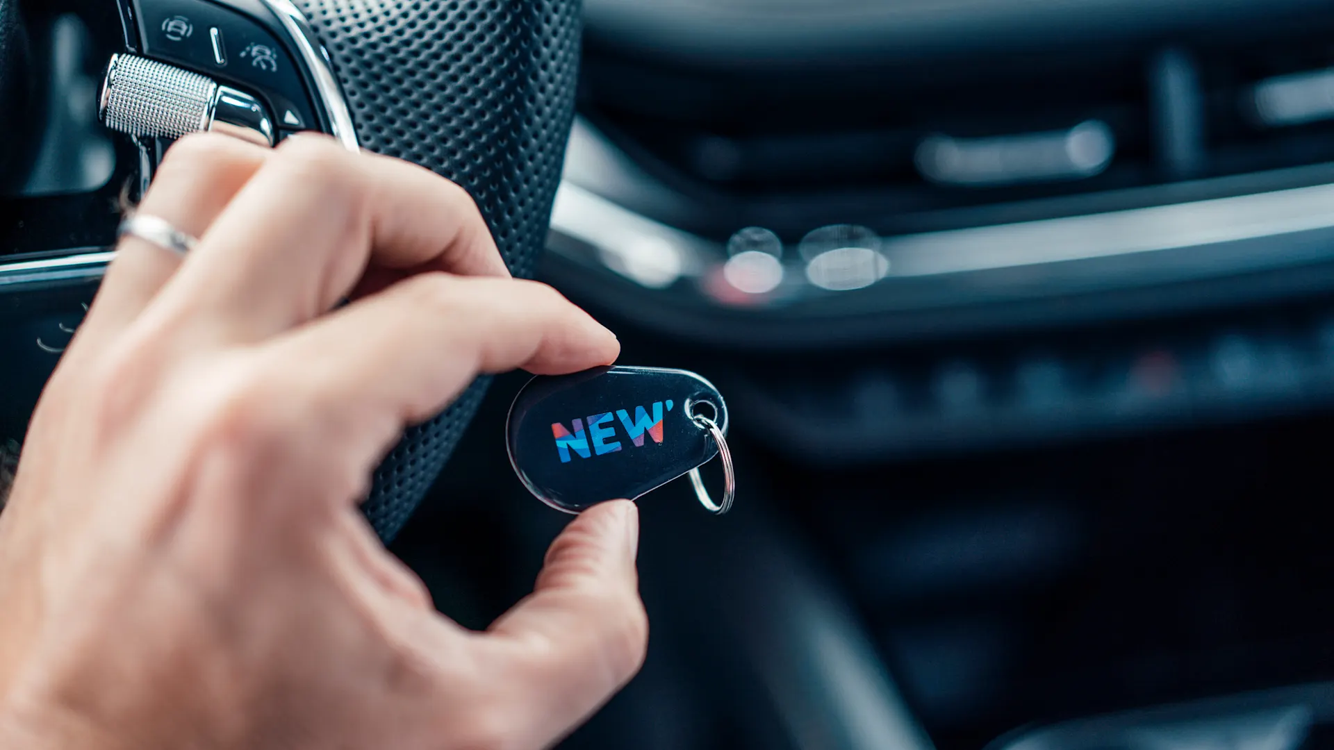 Ladetoken Eine Person hält einen Ladetoken der NEW in der Hand.