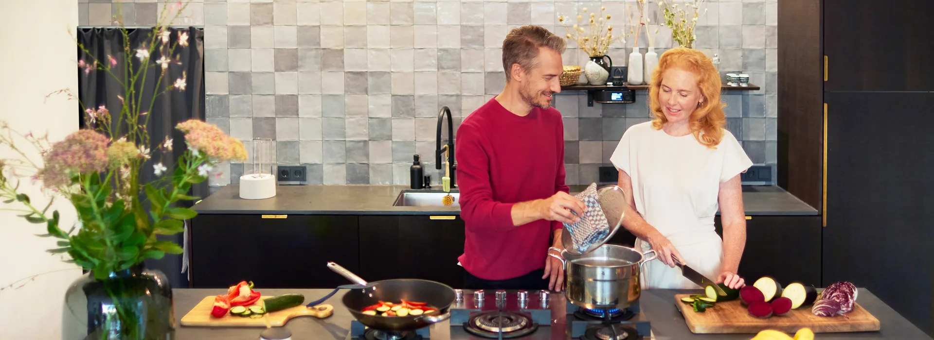 Gemeinsames Kochen mit Gas von der NEW Energie Paar steht in der Küche und kocht gemeinsam am Gasherd. Der Gasherd wird betrieben mit Gas von der NEW Energie.