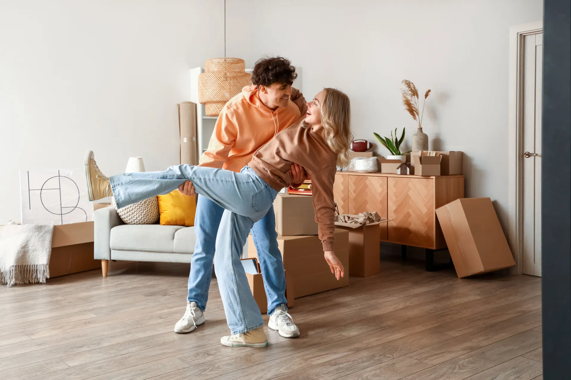 Das junge Pärchen steht glücklich in einer Wohnung.