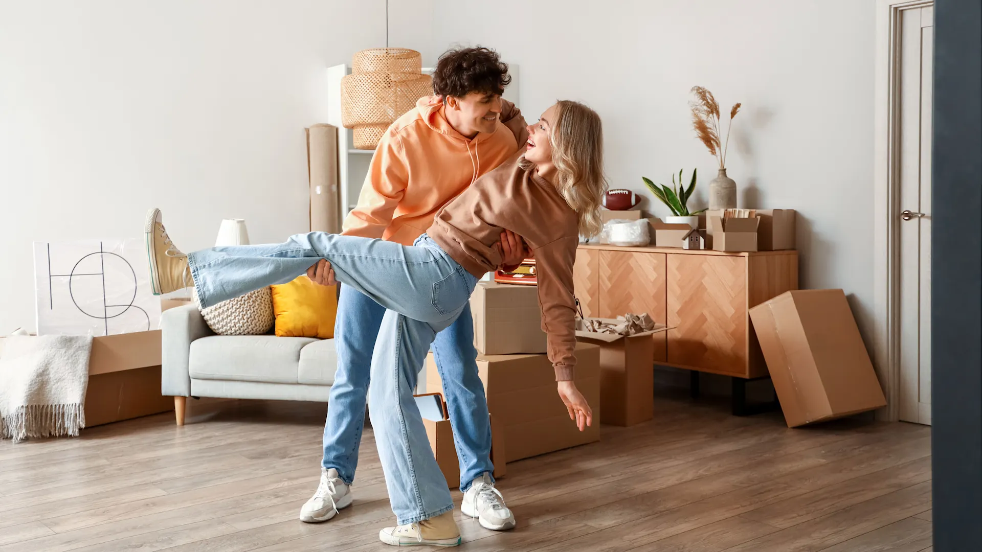 Junges Pärchen in der neuen Wohnung Das junge Pärchen steht glücklich in einer Wohnung. Siefreuen sich über gute Preise der NEW Energie.