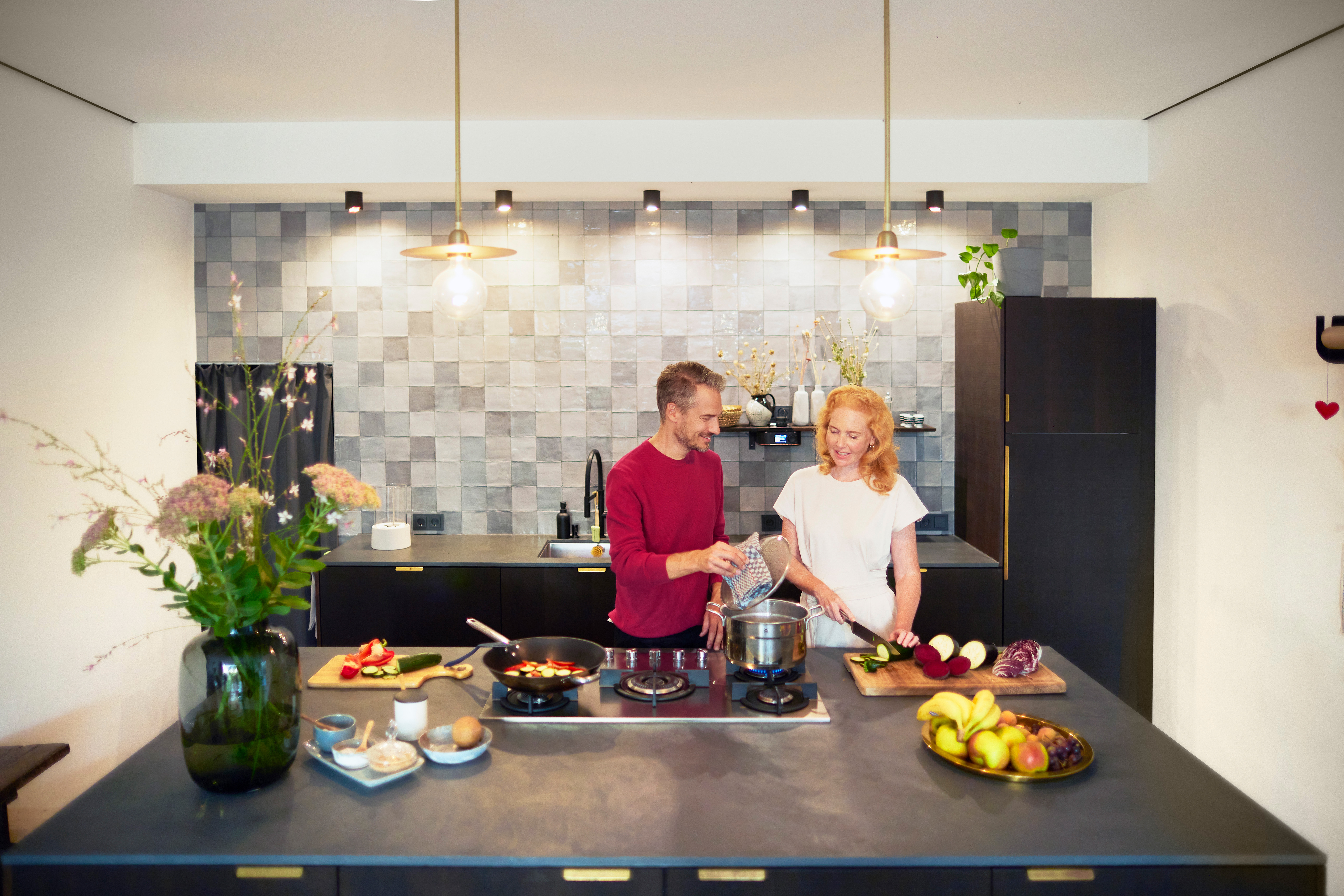 Ein Paar verbringt seine Zeit mit gemeinsamen Kochen in der Küche und nutzt dabei günstige Energie von der NEW Energie.