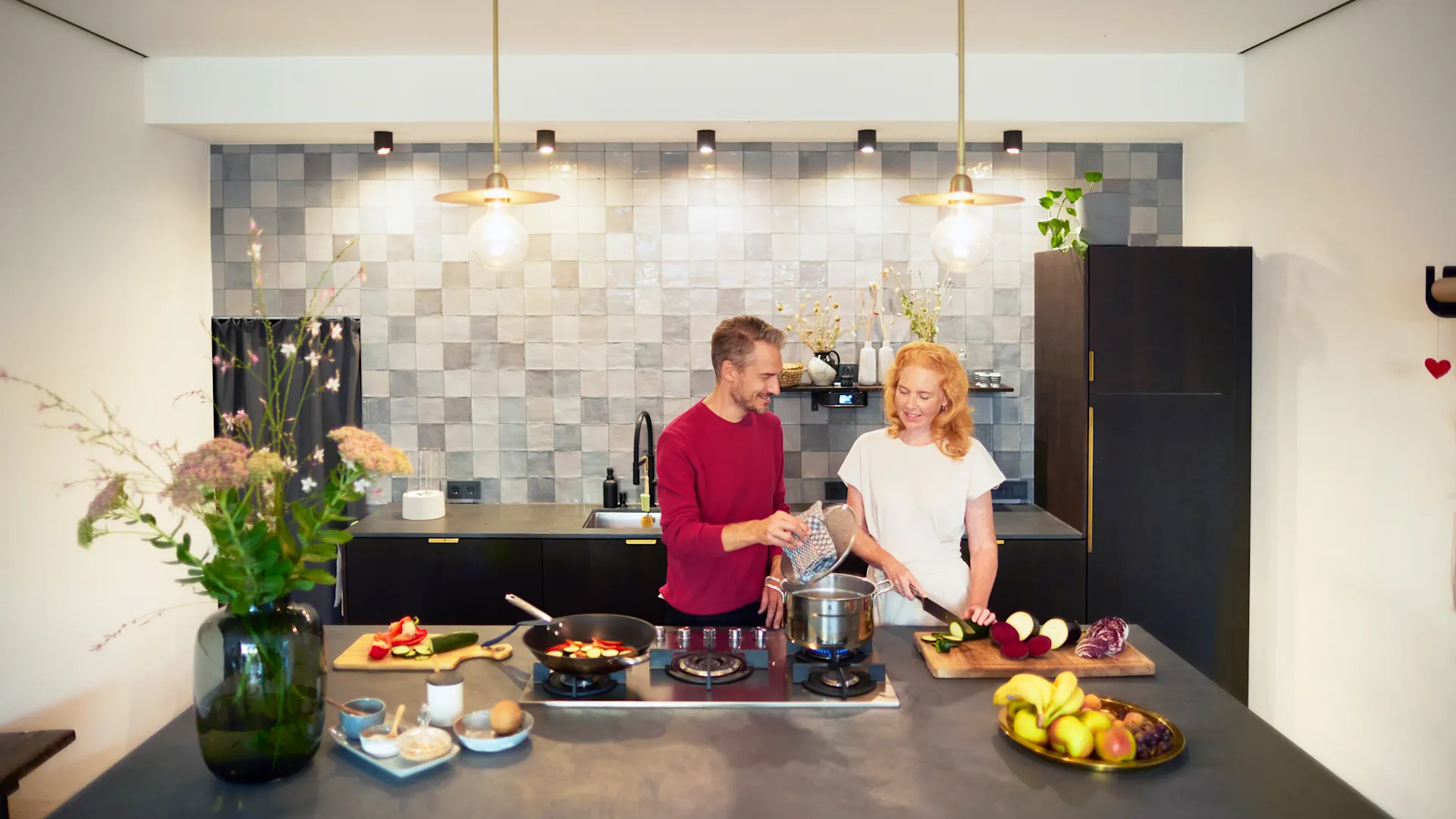 Gemeinsames Kochen Ein Paar verbringt seine Zeit mit gemeinsamen Kochen in der Küche und nutzt dabei günstige Energie von der NEW Energie.