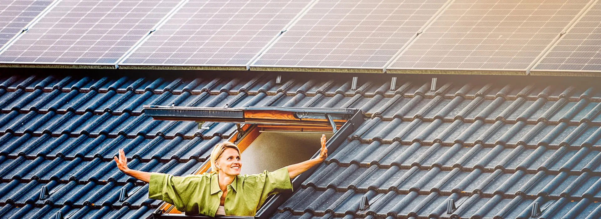 Frühjahr-Deal: 500€ Rabatt auf PV-Anlagen Eine Frau schaut strahlend aus dem Fenster. Über dem Fenster sind PV-Anlagen der NEW Energie montiert.