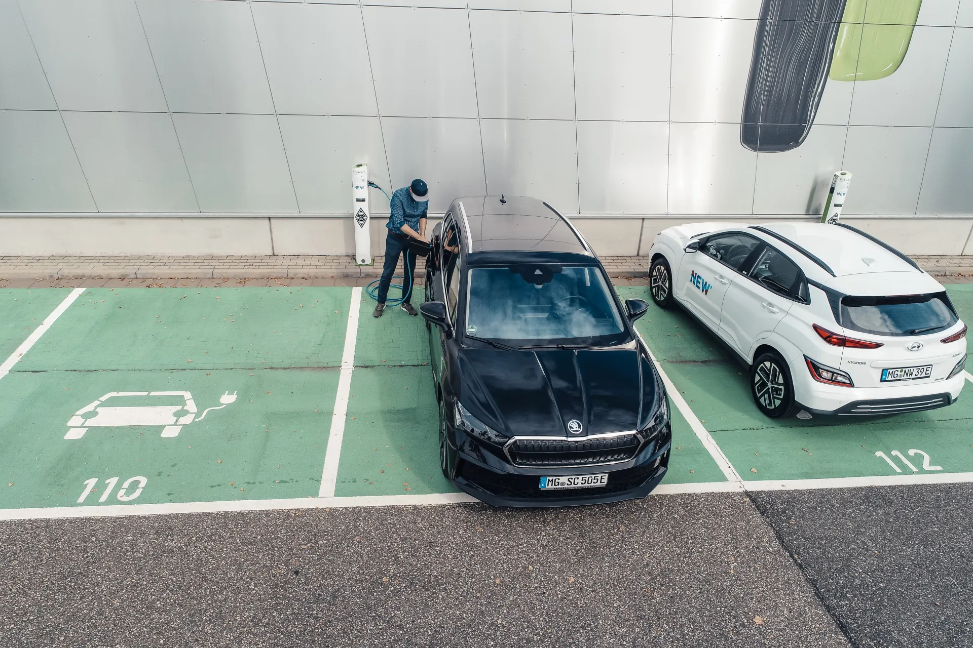 Ein Mann lädt sein Elektroauto an einer öffentlichen Ladesäule.