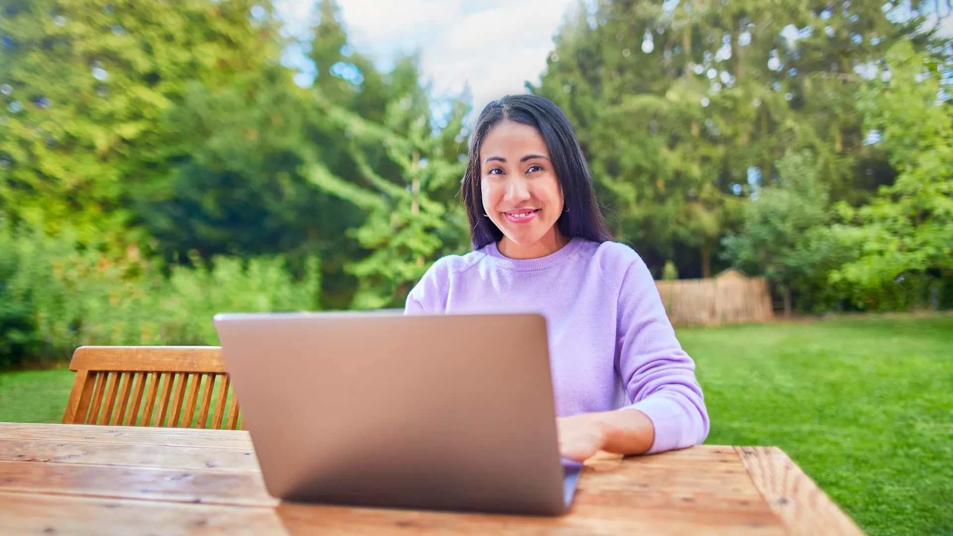 Tarifauswahl am Laptop Eine Frau sitzt mit ihrem Laptop im Garten und informiert sich über die Tarifauswahl der NEW Energie.