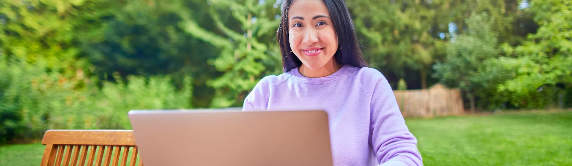 Tarifauswahl am Laptop Eine Frau sitzt mit ihrem Laptop im Garten und informiert sich über die Tarifauswahl der NEW Energie.