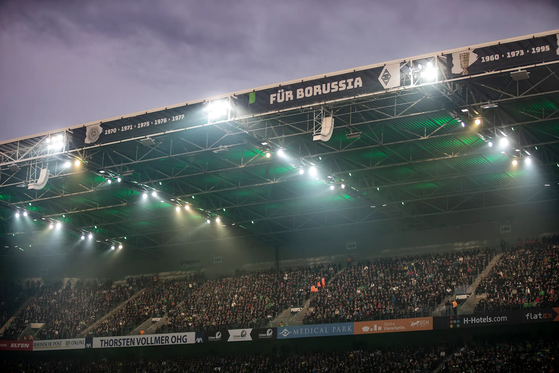 Fanpower auf der Tribüne mit Fohlenstrom Tribüne von Borussia Mönchengladbach während eines Heimspiels am Abend.