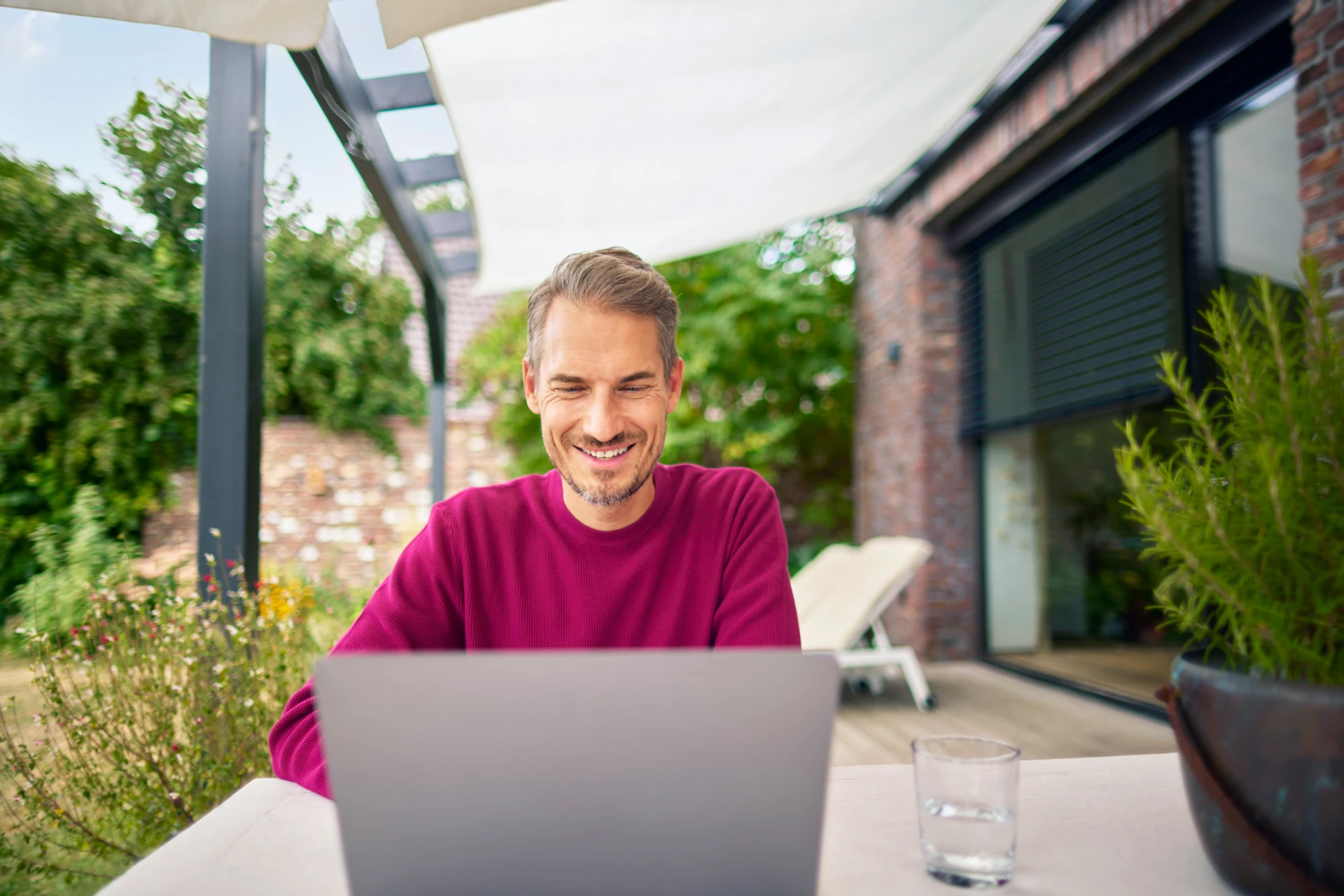 Ein Mann sitzt im Garten mit einem Laptop und informiert sich ueber die guenstigen Tarife, insbesondere die Tarifauswahl bei den Oekotarifen, bei der NEW Energie .