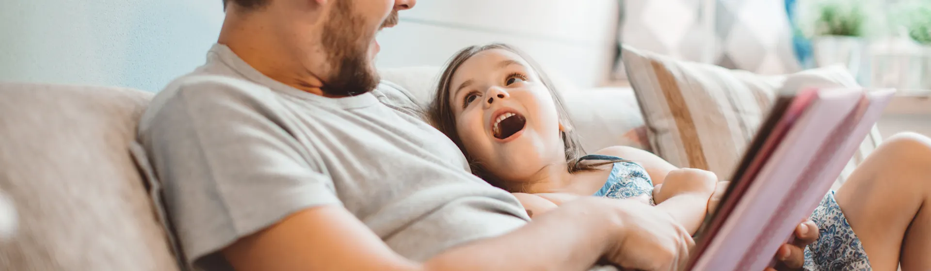 Vater mit Tochter auf dem Sofa mit Tablet Vater surft mit Tochter im Internet auf dem Tablet und sitzen dabei auf einem Sofa.