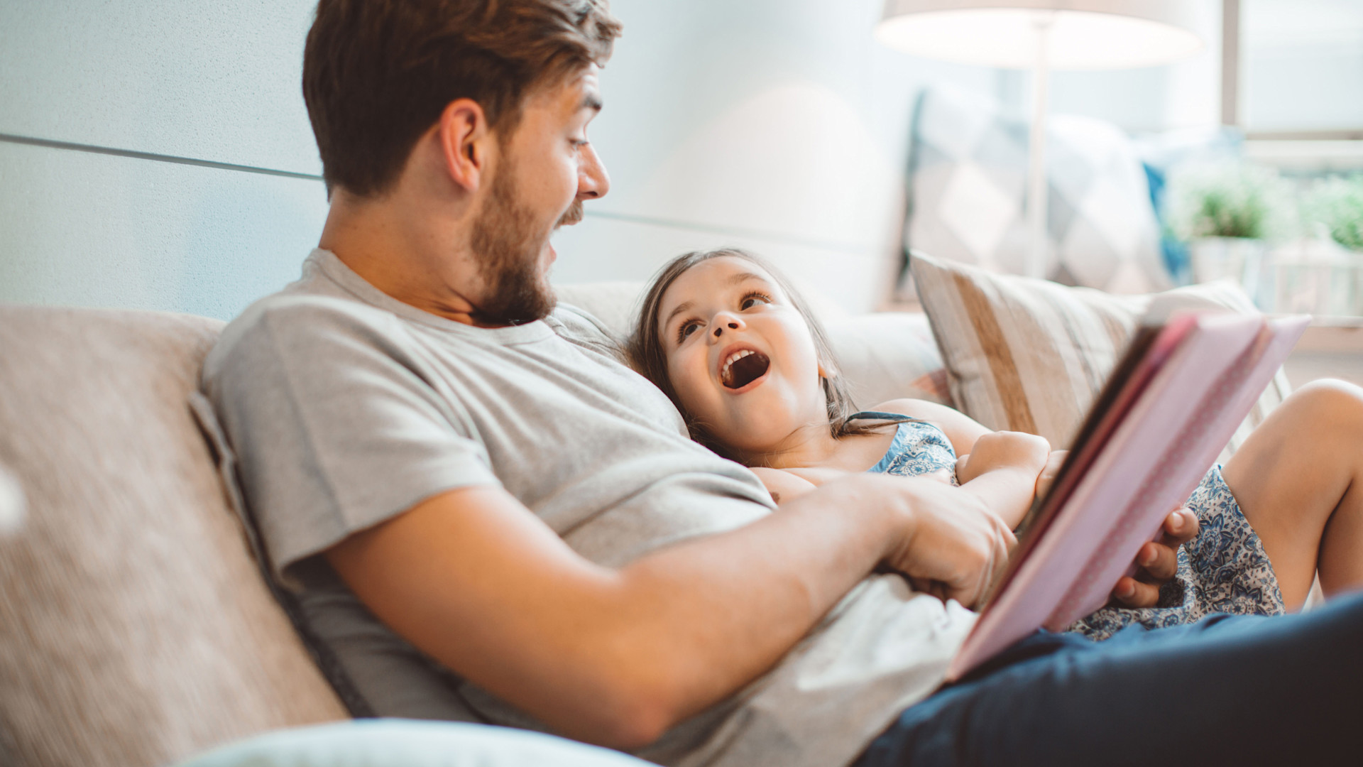 Vater surft mit Tochter im Internet auf dem Tablet.