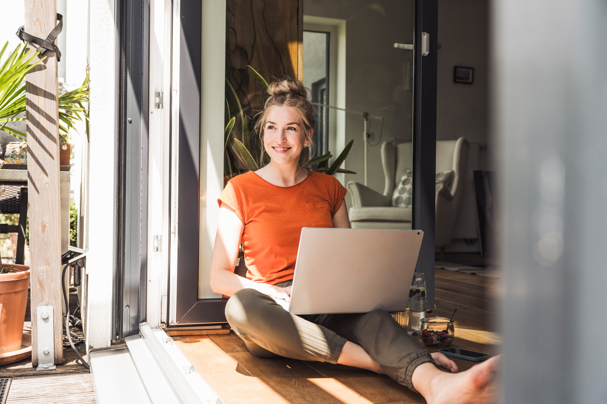 Eine Frau sitzt am Laptop und möchte für Strom und Gas zur NEW Energie wechseln.