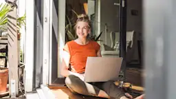 Günstig, fair und ausgezeichneter Service bei der NEW Energie Eine Frau sitzt am Laptop und möchte für Strom und Gas zur NEW Energie wechseln.