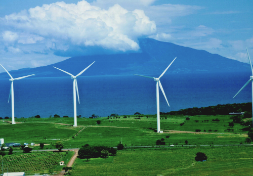 Projektfoto Windenergie Nicaragua. Blick auf drei Windräder im grünen von Nicaragua.