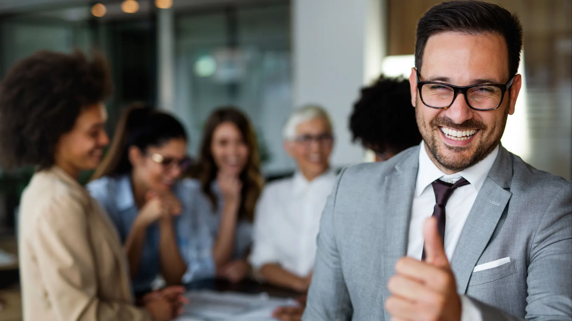 Kollegen stehen im Büro am Tisch und reden über günstige Energie für Gewerbe- und Großkunden.