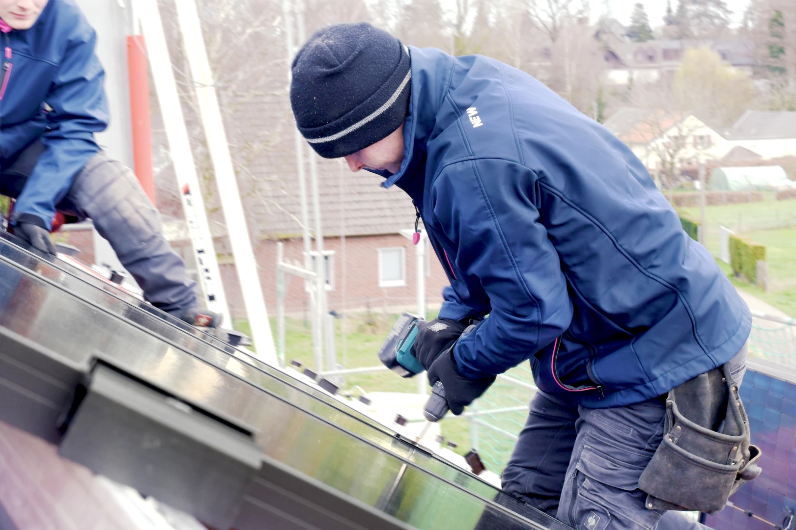 Ein Mitarbeiter der NEW Energie montiert eine PV Anlage, welche ein Energiedach zur Herstellung von kostengünstigen Ökostrom darstellt.
