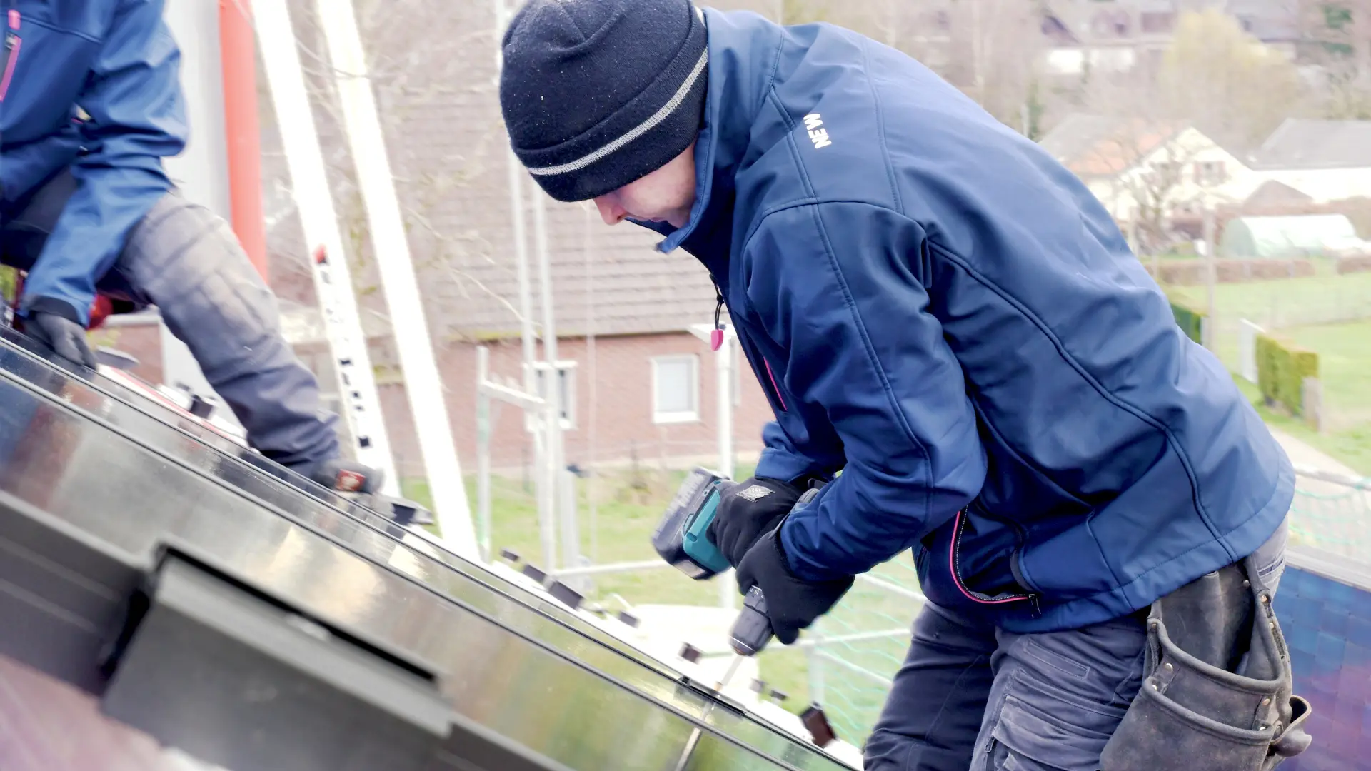 Ein Mitarbeiter der NEW Energie montiert eine PV Anlage, welche ein Energiedach zur Herstellung von kostengünstigen Ökostrom darstellt.