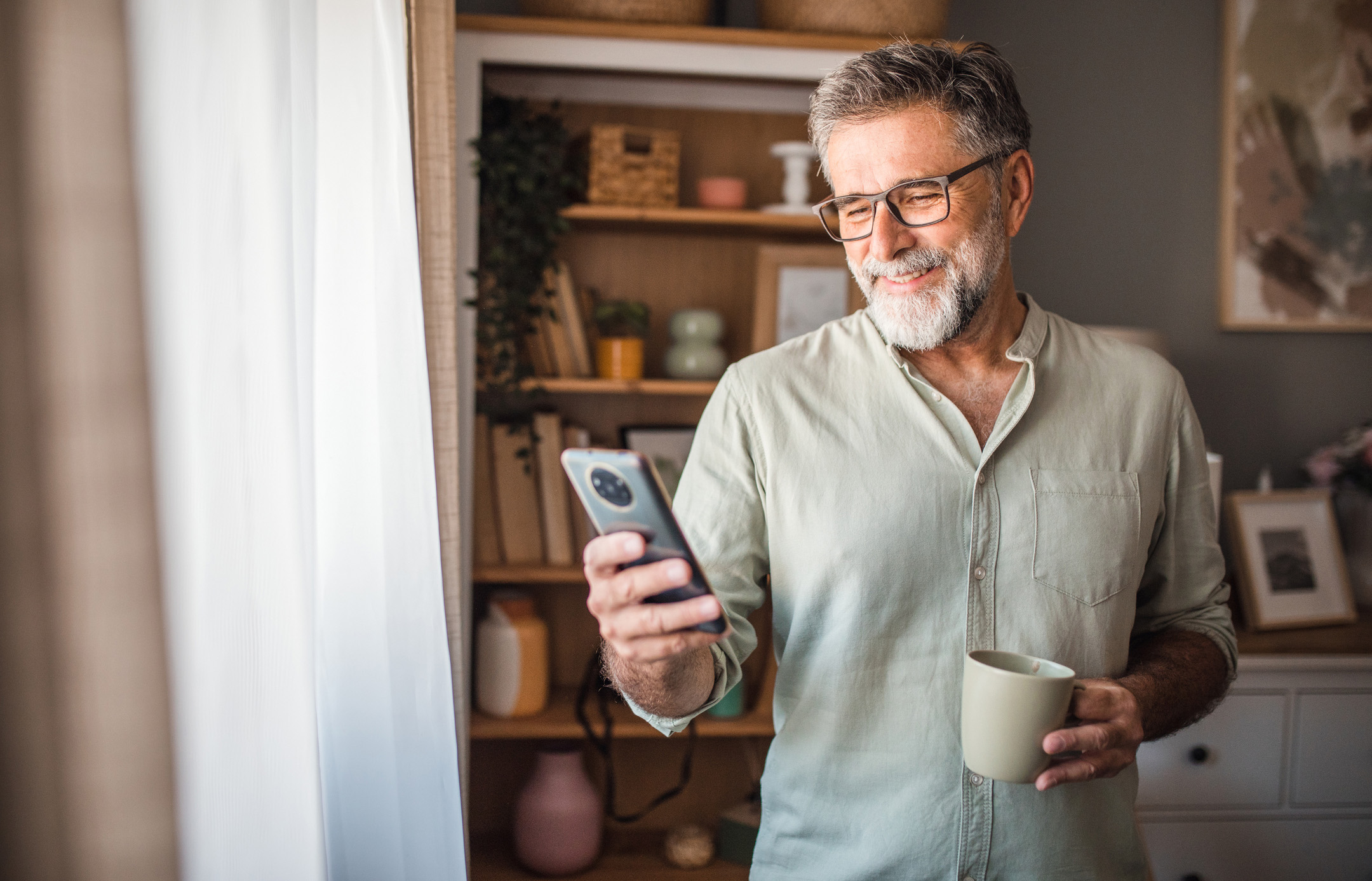 Ein Mann informiert sich an seinem Smartphone über den guten Wechselservice bei der NEW Energie.