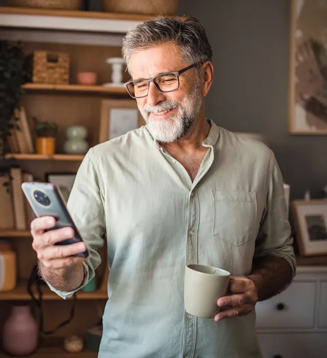 Rundum-sorglos-Service bei der NEW Energie Ein Mann informiert sich an seinem Smartphone über den guten Wechselservice bei der NEW Energie.