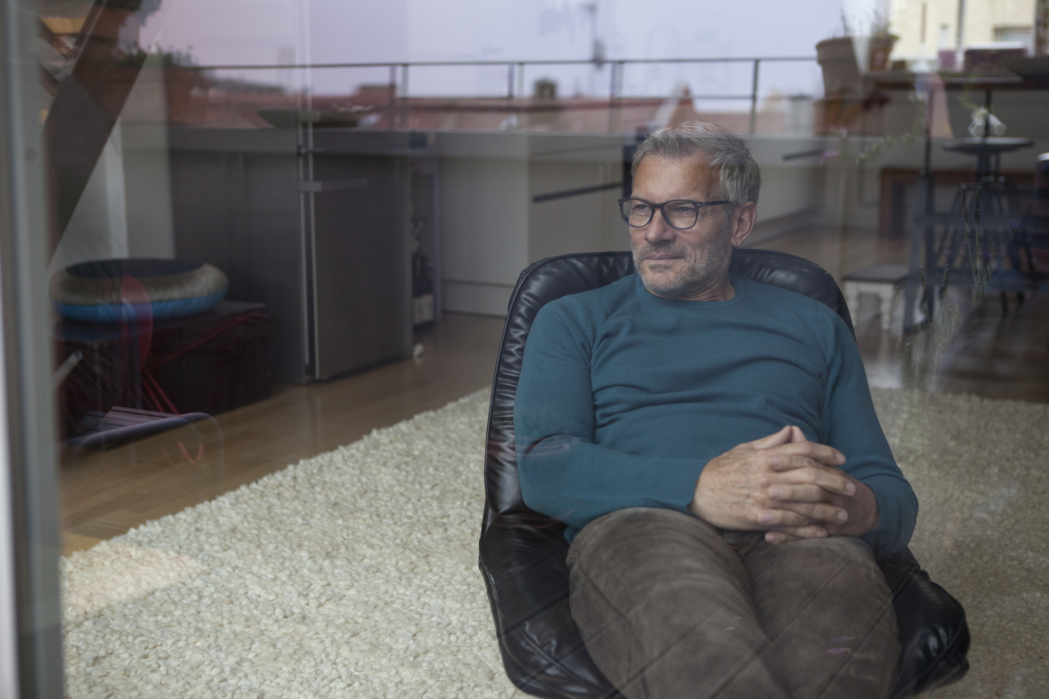 Ein Mann sitzt in einem Sessel und denkt über die Tarife der NEW Energie nach. 