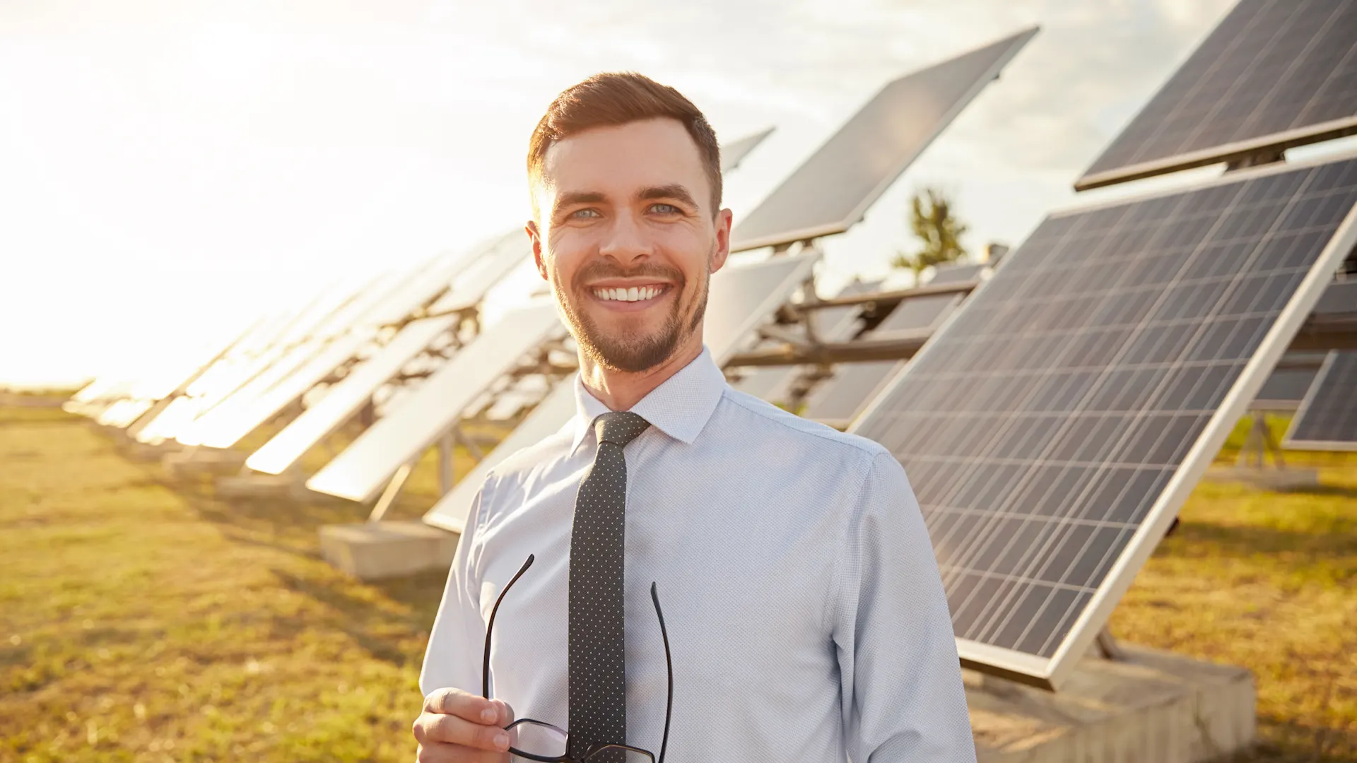 Geschäftsmann vor großer Photovoltaik Anlage Geschäftsmann steht vor einer Photovoltaikanlage der NEW Energie.