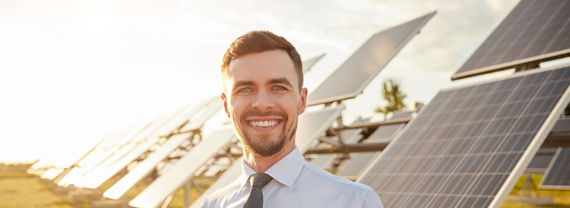 Geschäftsmann vor großer Photovoltaik Anlage Geschäftsmann steht vor einer Photovoltaikanlage der NEW Energie.