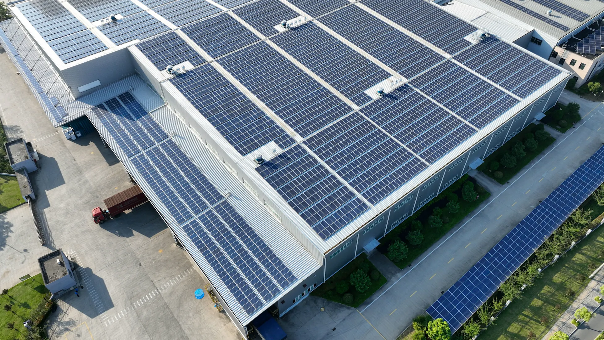 Sicht von oben auf einen großen Gebäudekomplex mit Photovoltaikanlage Lautaufnahme eines großen Gebäudekomplexes mit einer Photovoltaikanlage auf dem Dach.