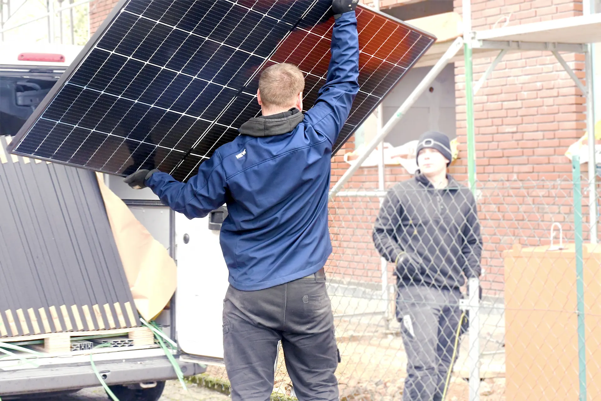 Ein Mitarbeiter der NEW Energie ist mit der Lieferung einer PV Anlage beschaeftigt.