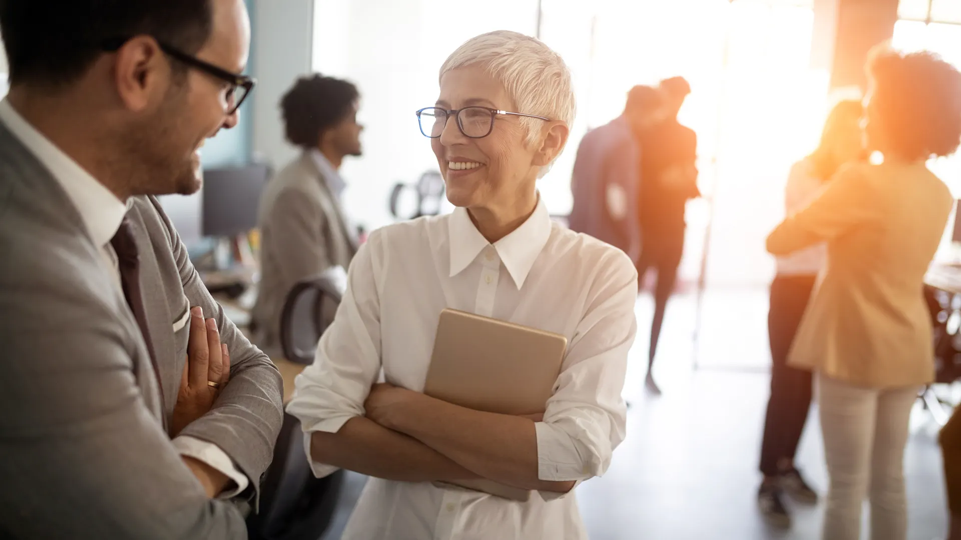 Kollegen im Gespräch über Energielösungen Kollegen unterhalten sich angeregt in einem großen Raum in einem Bürogebäude.