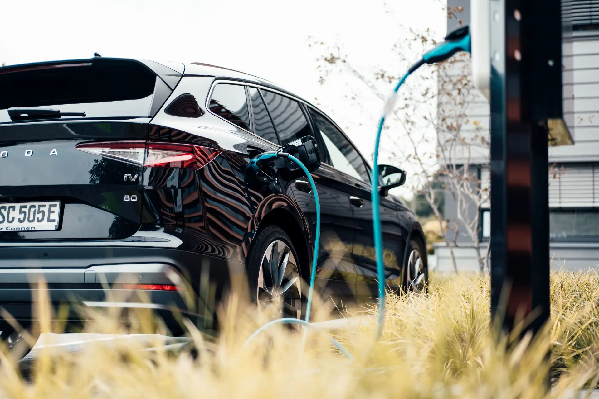 Elektroauto steht an einer Ladesäule mit eingestecktem Ladekabel und wird mit Autostrom geladen.