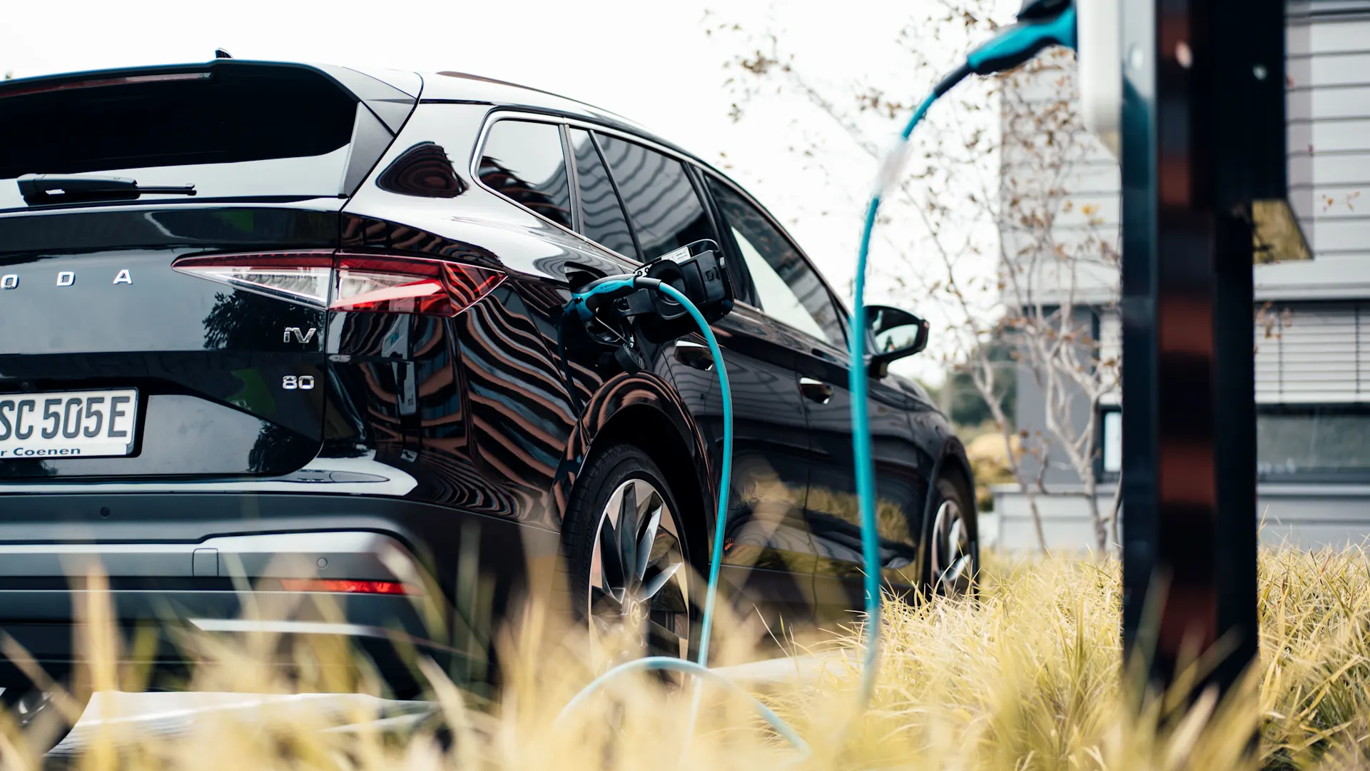 E-Auto mit eingestecktem Ladekabel Elektroauto steht an einer Ladesäule mit eingestecktem Ladekabel und wird mit Autostrom von der NEW Energie geladen.