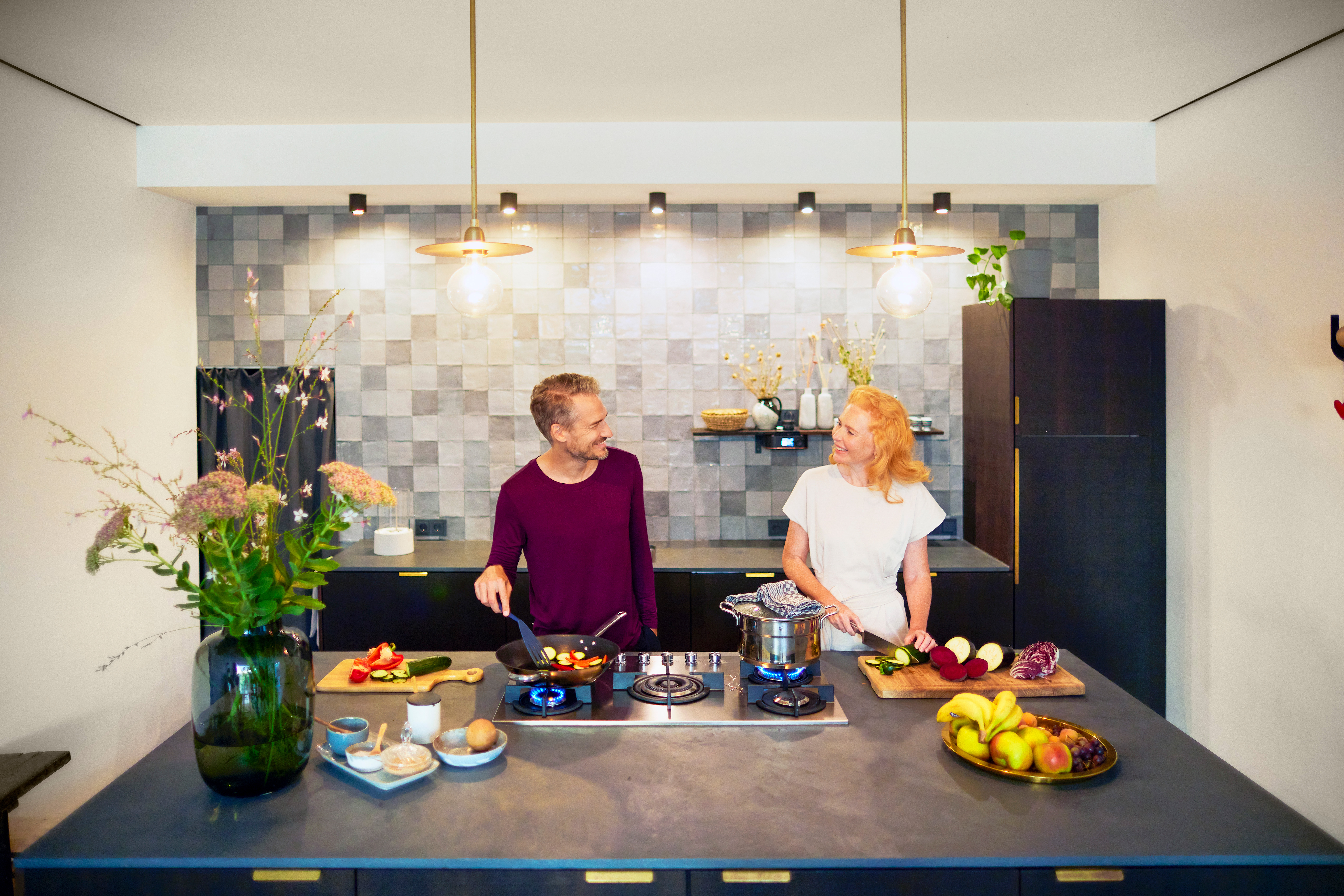 Zur Vorbereitung des Abendessens ist ein Paar am kochen mit günstigen Ökogas von dem Stromanbieter NEW Energie.