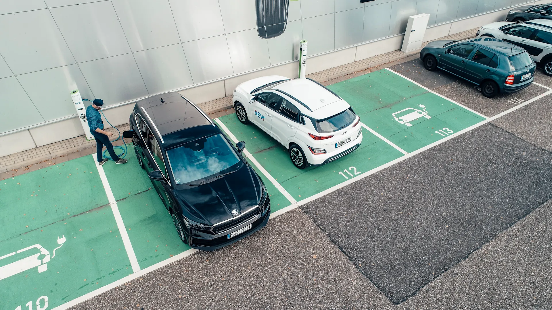 E-Ladestationen Einige E-Autos stehen auf Parkplätzen zum Aufladen am Borussia-Park. Ein Mann lädt gerade sein Auto an einer NEW-Ladestation auf.