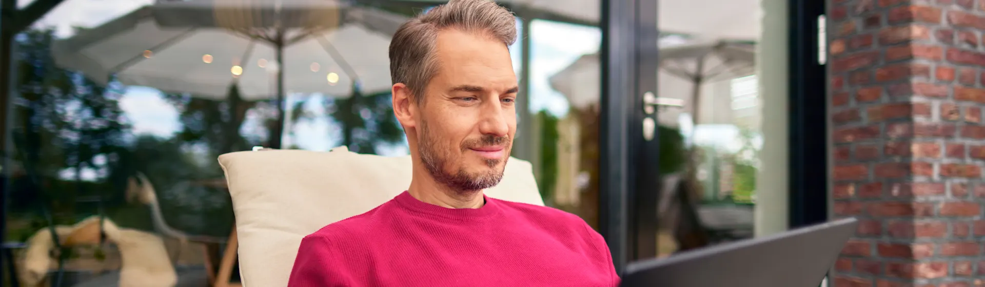 Produktwelt der NEW Energie Ein Mann liegt auf einer Gartenliege mit einem Tablet in der Hand und informiert sich über die Produktwelt der NEW Energie.