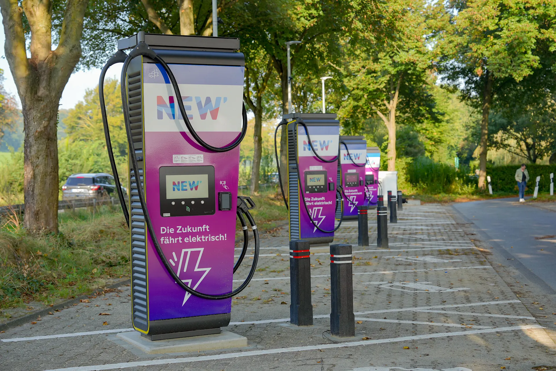 Mehrere Ladesäulen der NEW Energie stehen auf einem öffentlichen Parkplatz. 